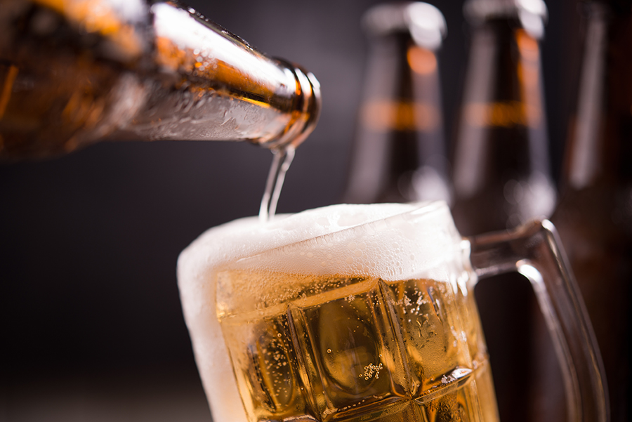 Glass bottles of beer with glass and ice on dark background cese actividad fundacion escym